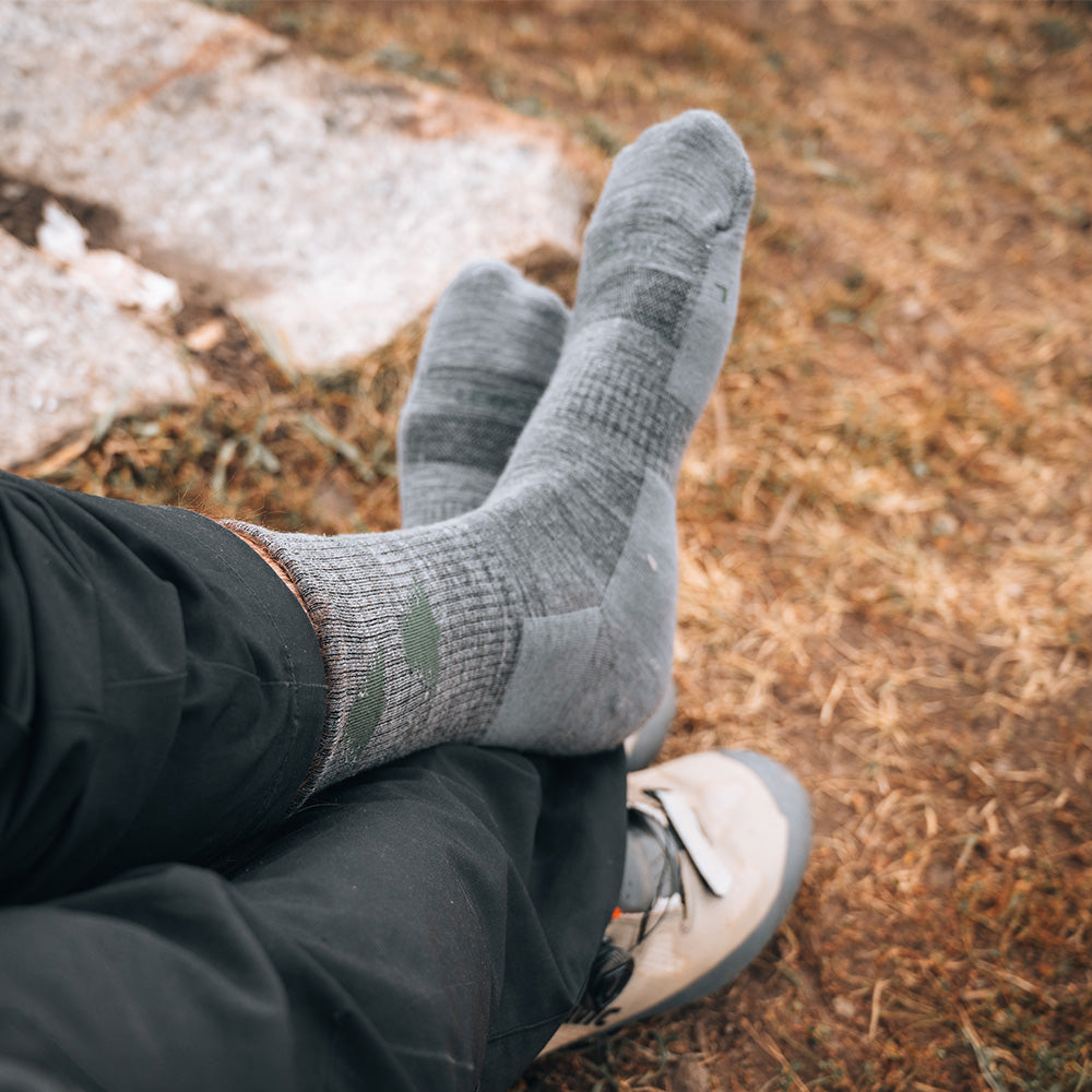Forest merino crew socks at a trail rest stop beside hiking boots