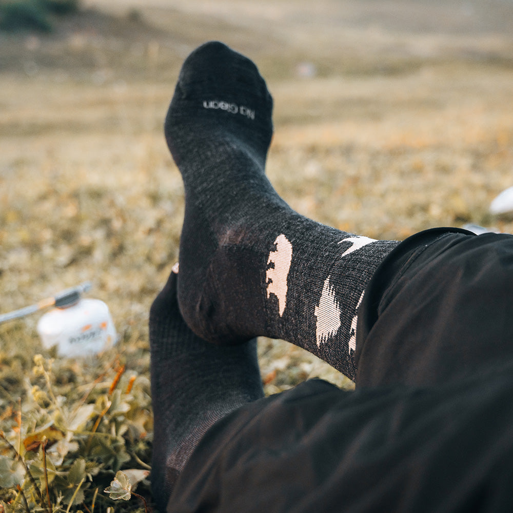 Jungle merino crew socks on grass at a trail break