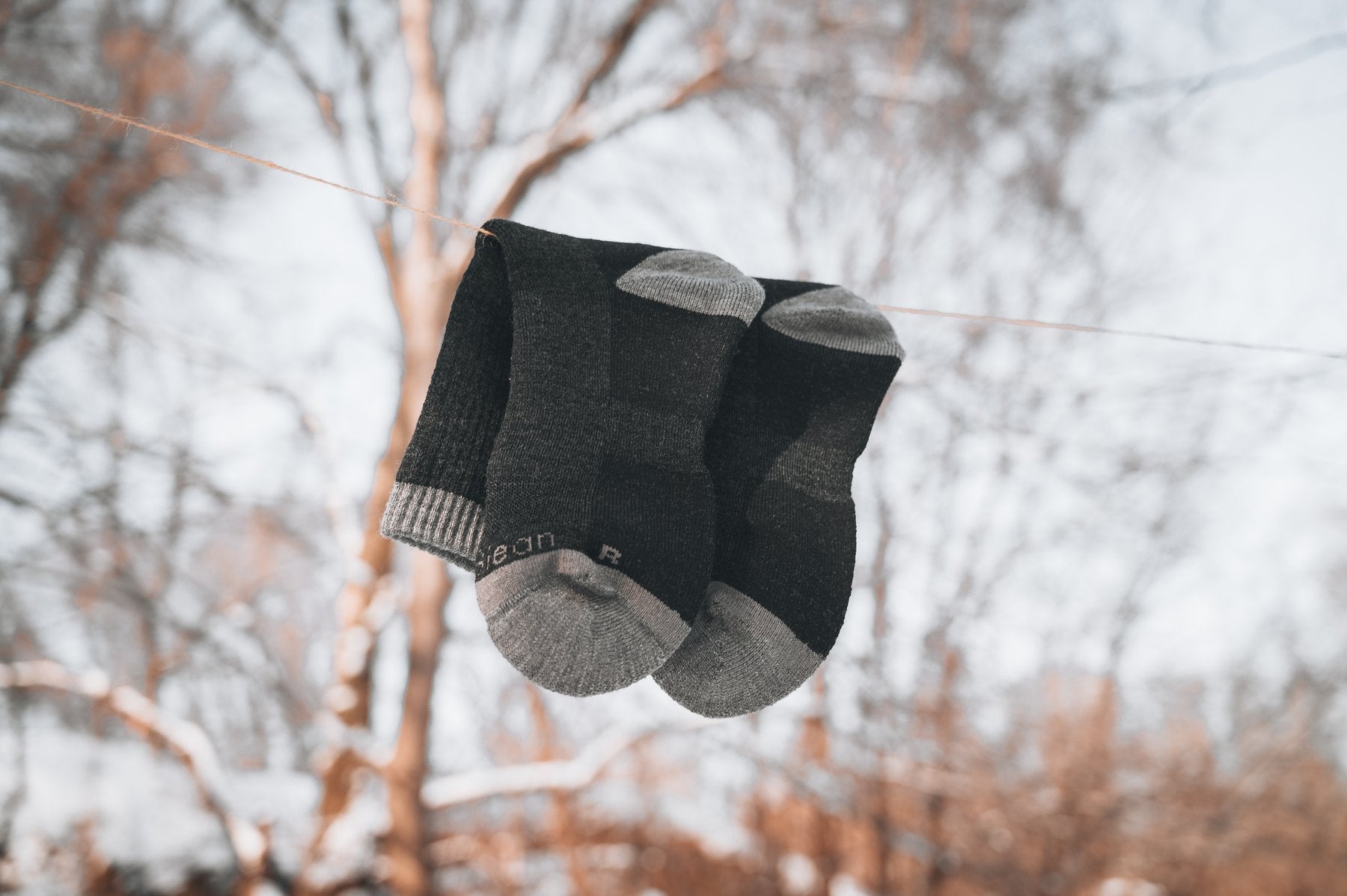 Hiking merino wool socks drying on a line in the snow